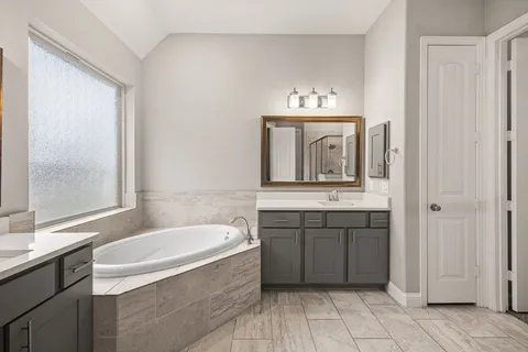 a bathroom with a bathtub sink and mirror