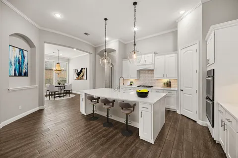 a kitchen with stainless steel appliances granite countertop a table chairs stove and refrigerator