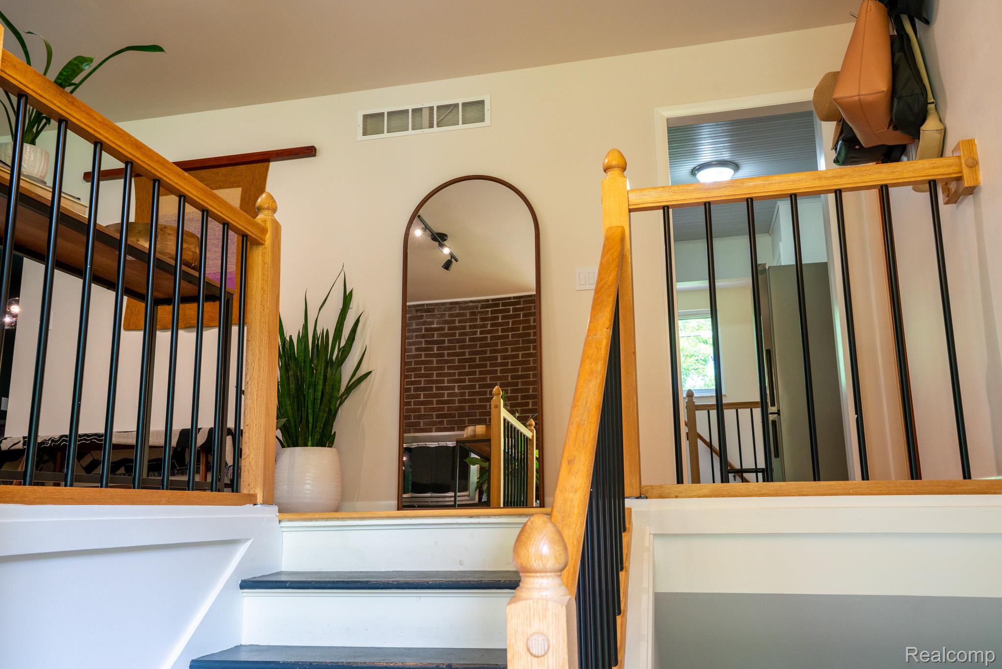 7333 Toma Road Dexter, MI 48130 - Photo 16 of 45 Split-level entryway featuring hardwood newel posts and handrails, black metal balusters, and painted stair treads