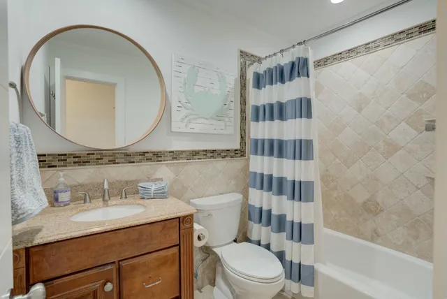 a bathroom with a granite countertop sink a mirror and a shower