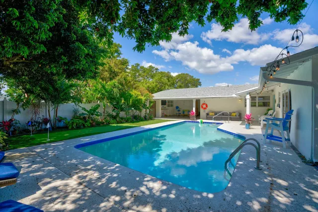 a view of a house with swimming pool and a chairs