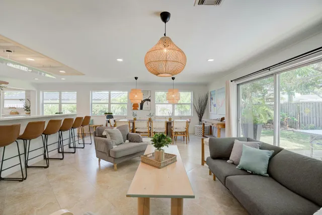 a living room with furniture chandelier and a large window