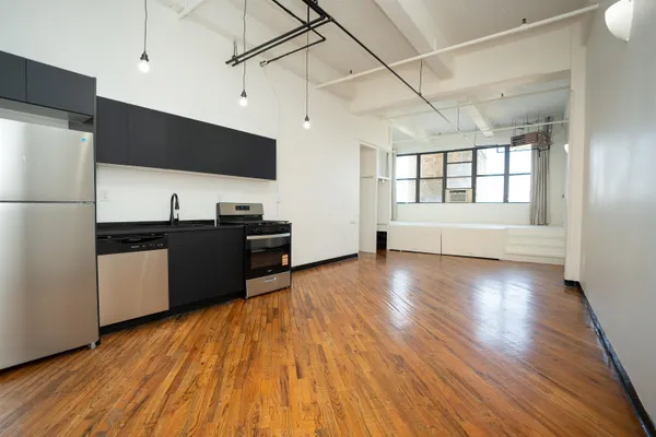 a view of a kitchen with a sink and dishwasher with wooden floor