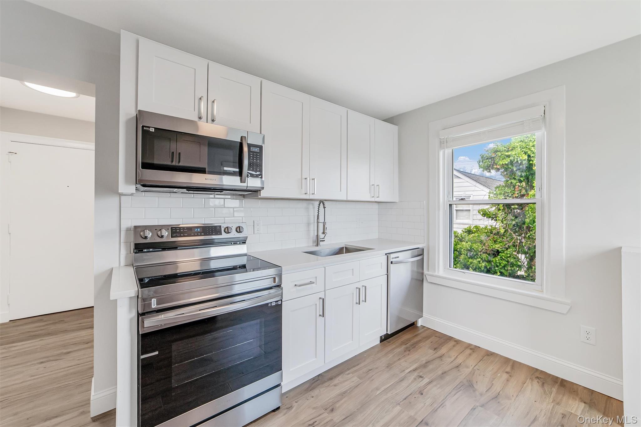 69 Prospect Street, Unit 2 Port Chester, NY 10573 - Photo 11 of 29 a kitchen with stainless steel appliances white cabinets and a stove top oven