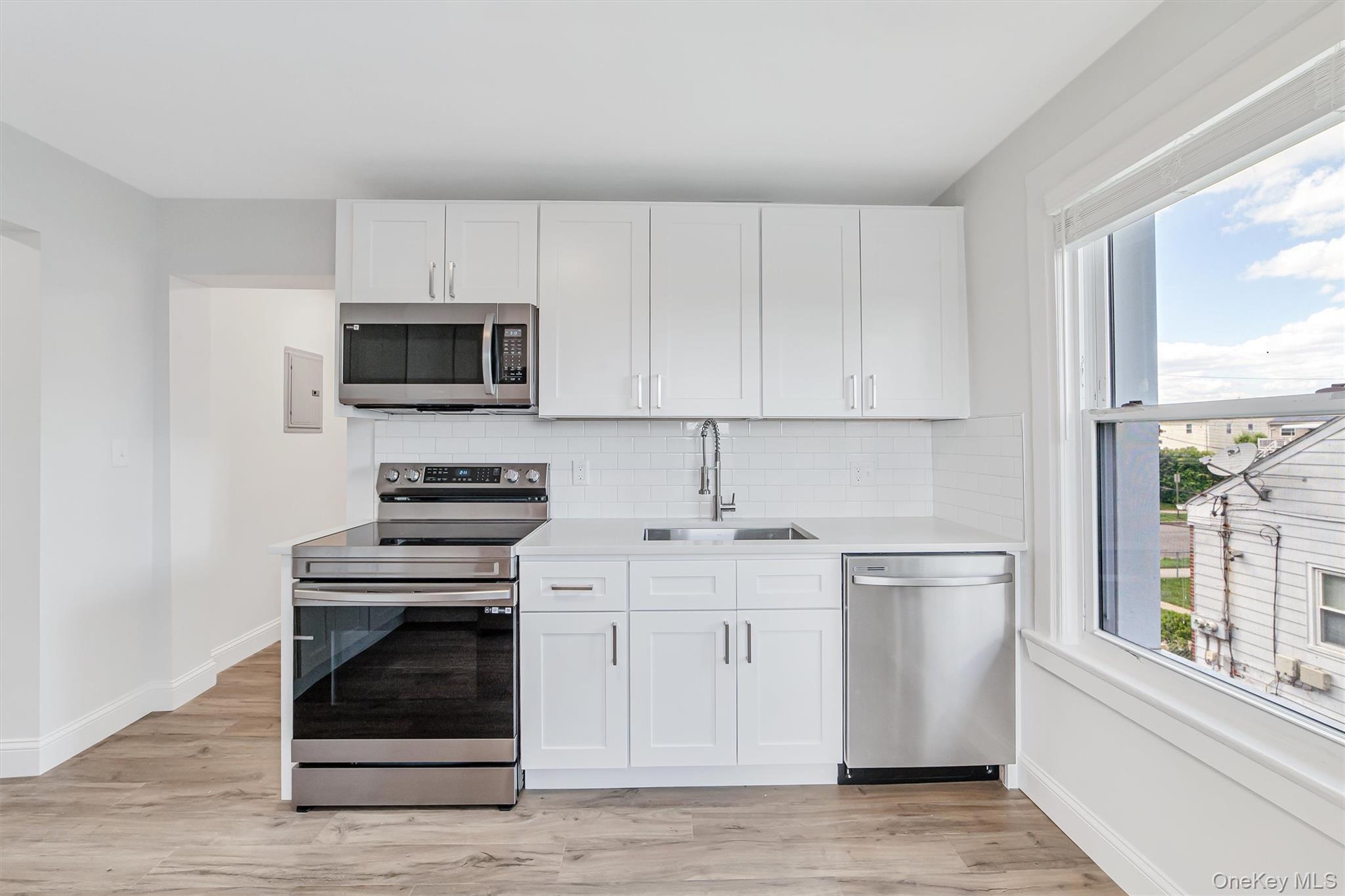 69 Prospect Street, Unit 2 Port Chester, NY 10573 - Photo 13 of 29 a kitchen with stainless steel appliances a stove a sink and a microwave