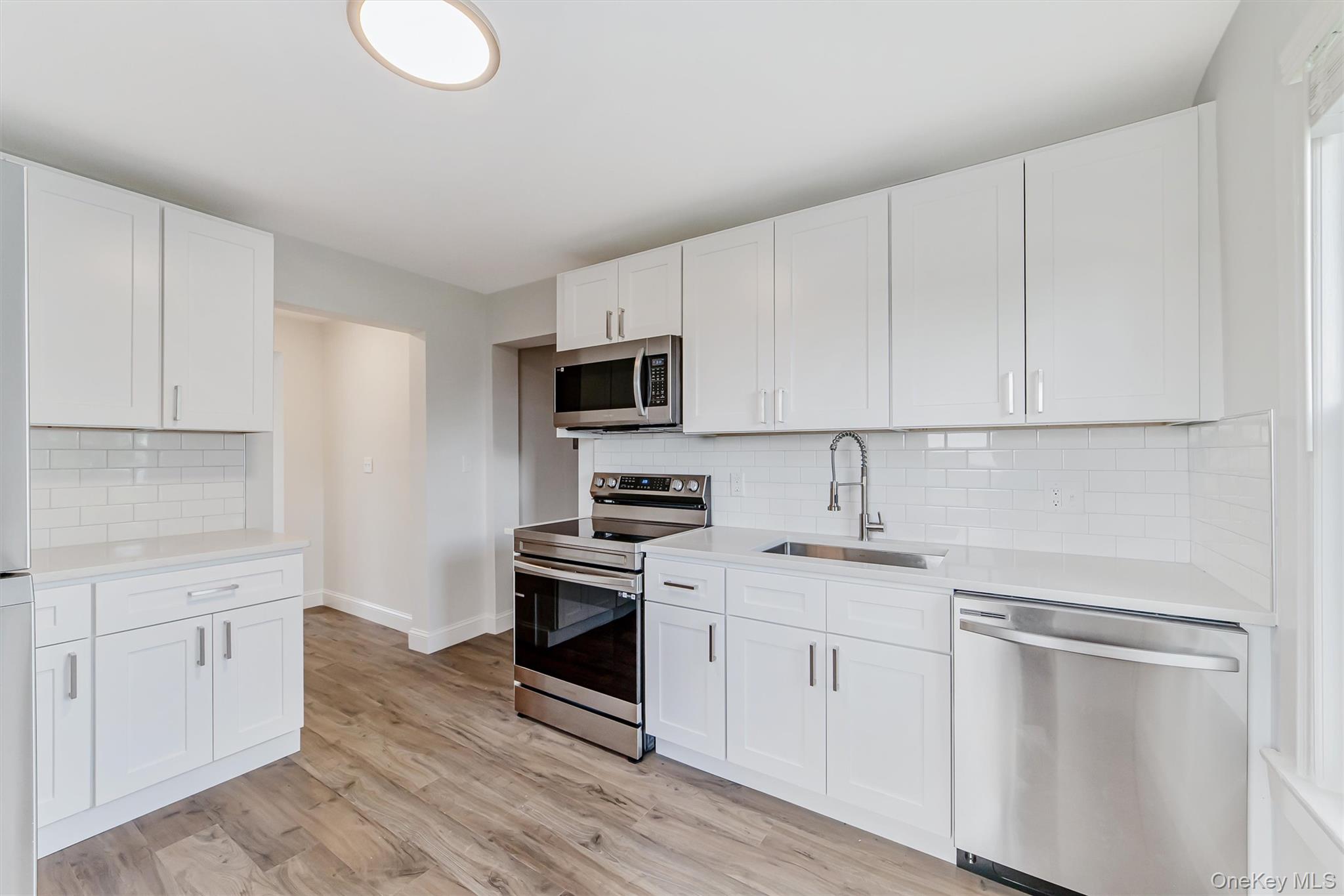 69 Prospect Street, Unit 2 Port Chester, NY 10573 - Photo 15 of 29 a kitchen with white cabinets stainless steel appliances and sink