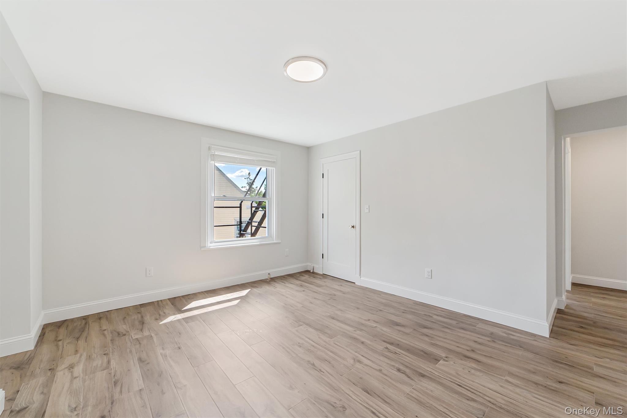 69 Prospect Street, Unit 2 Port Chester, NY 10573 - Photo 24 of 29 an empty room with wooden floor and windows