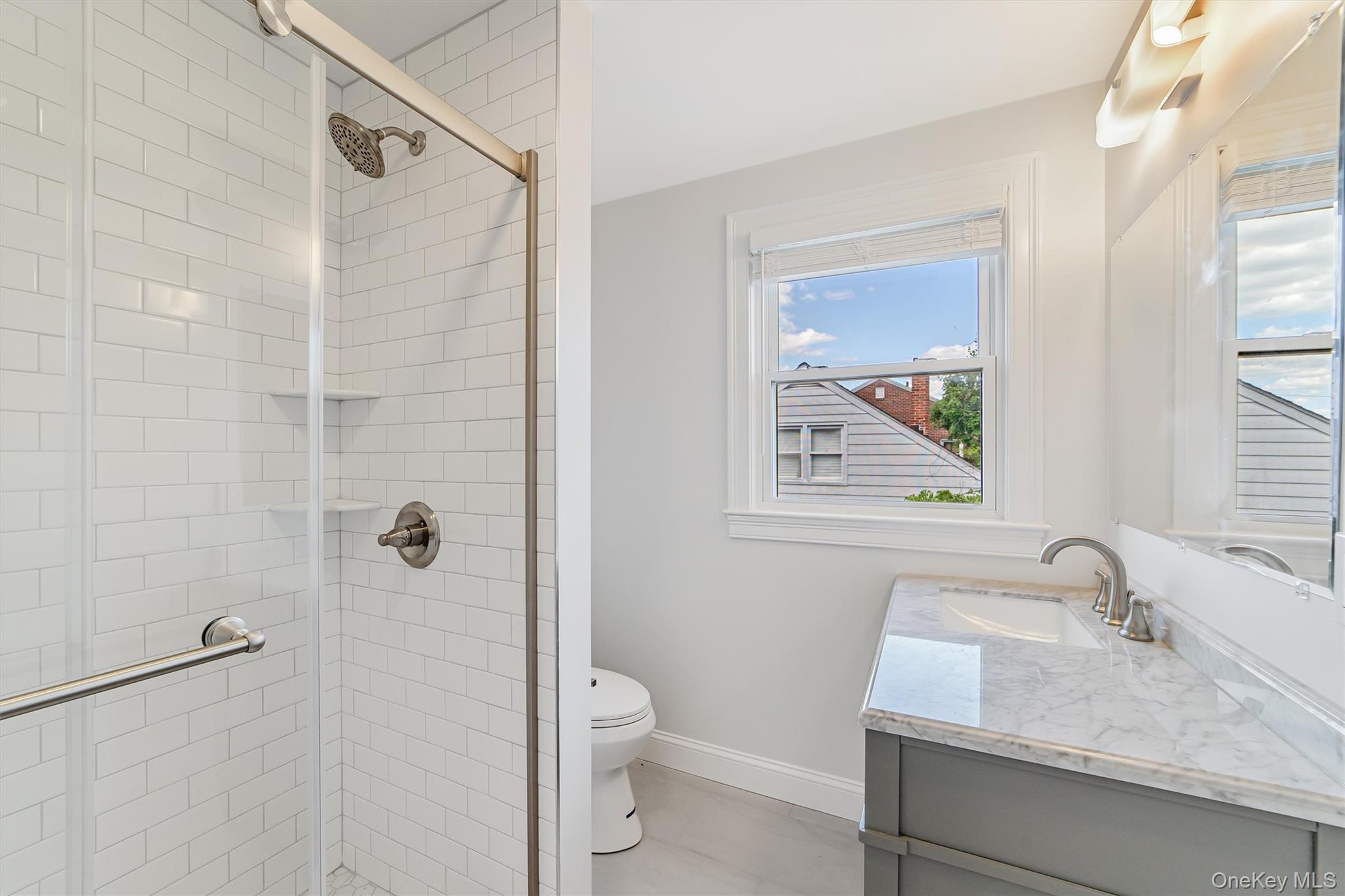 69 Prospect Street, Unit 2 Port Chester, NY 10573 - Photo 7 of 29 a bathroom with a granite countertop sink toilet and shower