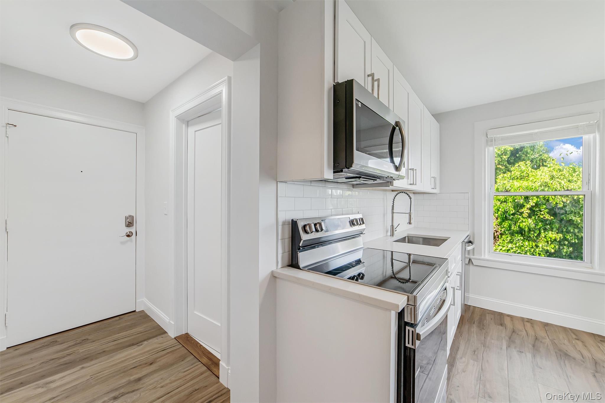 69 Prospect Street, Unit 2 Port Chester, NY 10573 - Photo 10 of 29 a kitchen with stainless steel appliances a stove microwave and sink