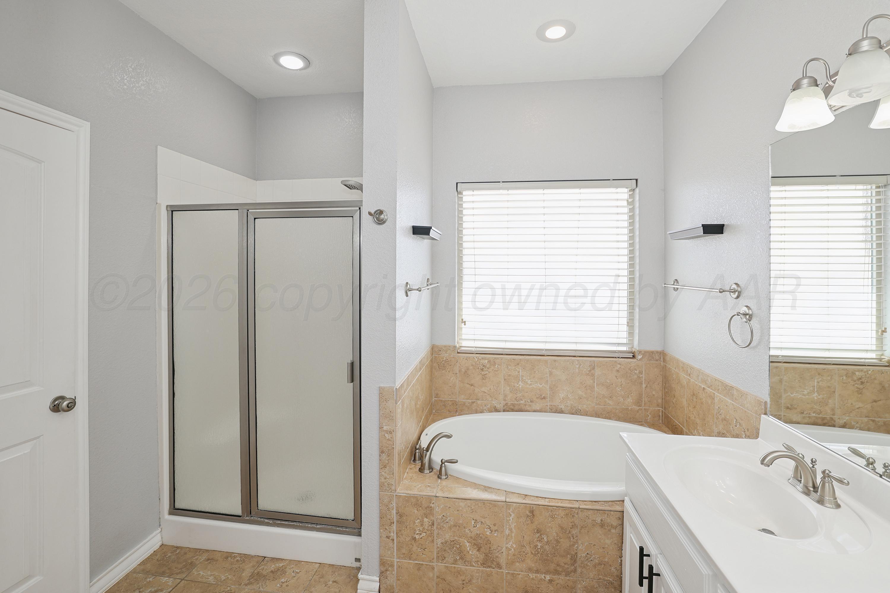 19101 Sundancer Lane Bushland, TX 79124 - Photo 12 of 25 a bathroom with a tub a sink and a window