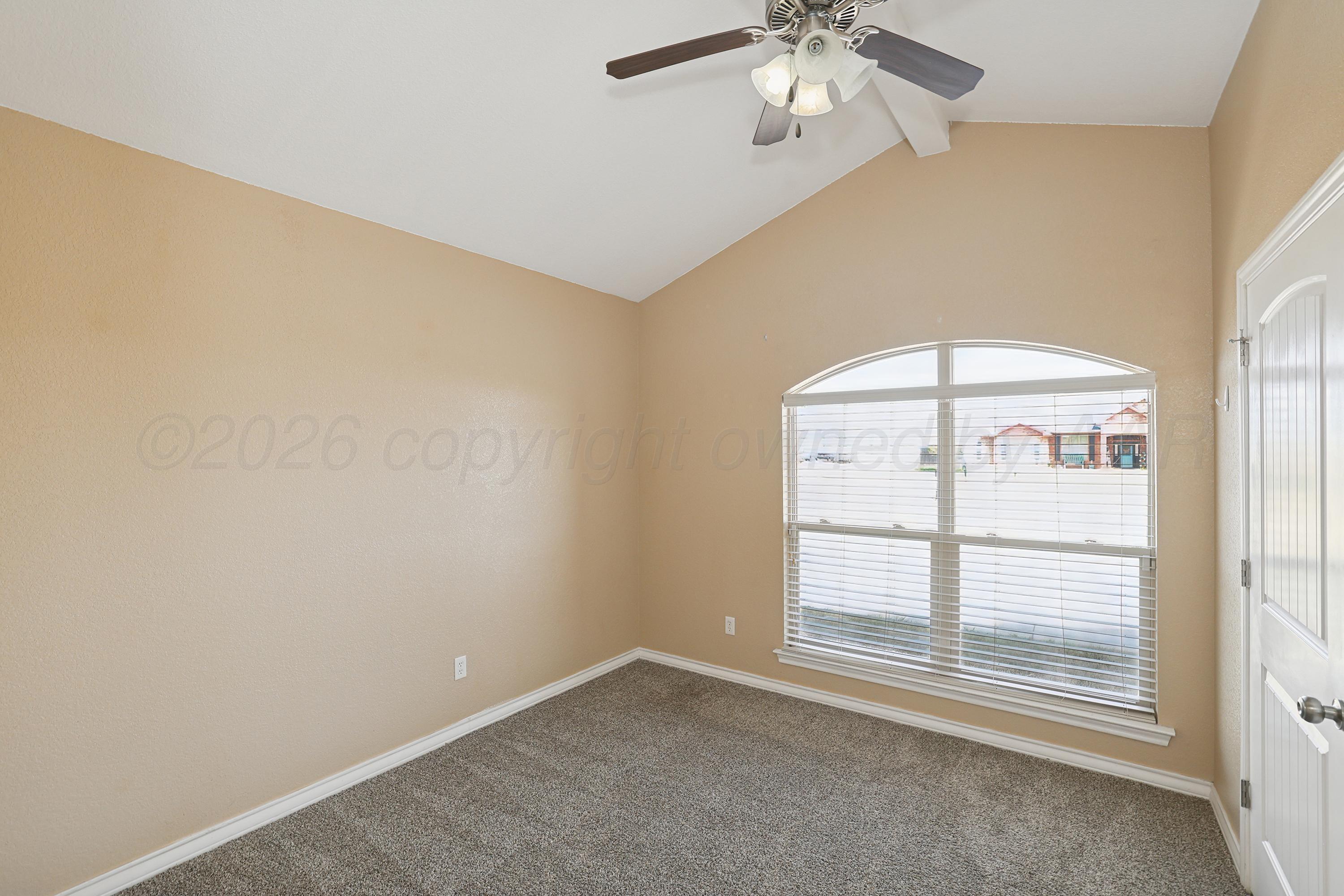 19101 Sundancer Lane Bushland, TX 79124 - Photo 18 of 25 an empty room with a chandelier fan and windows