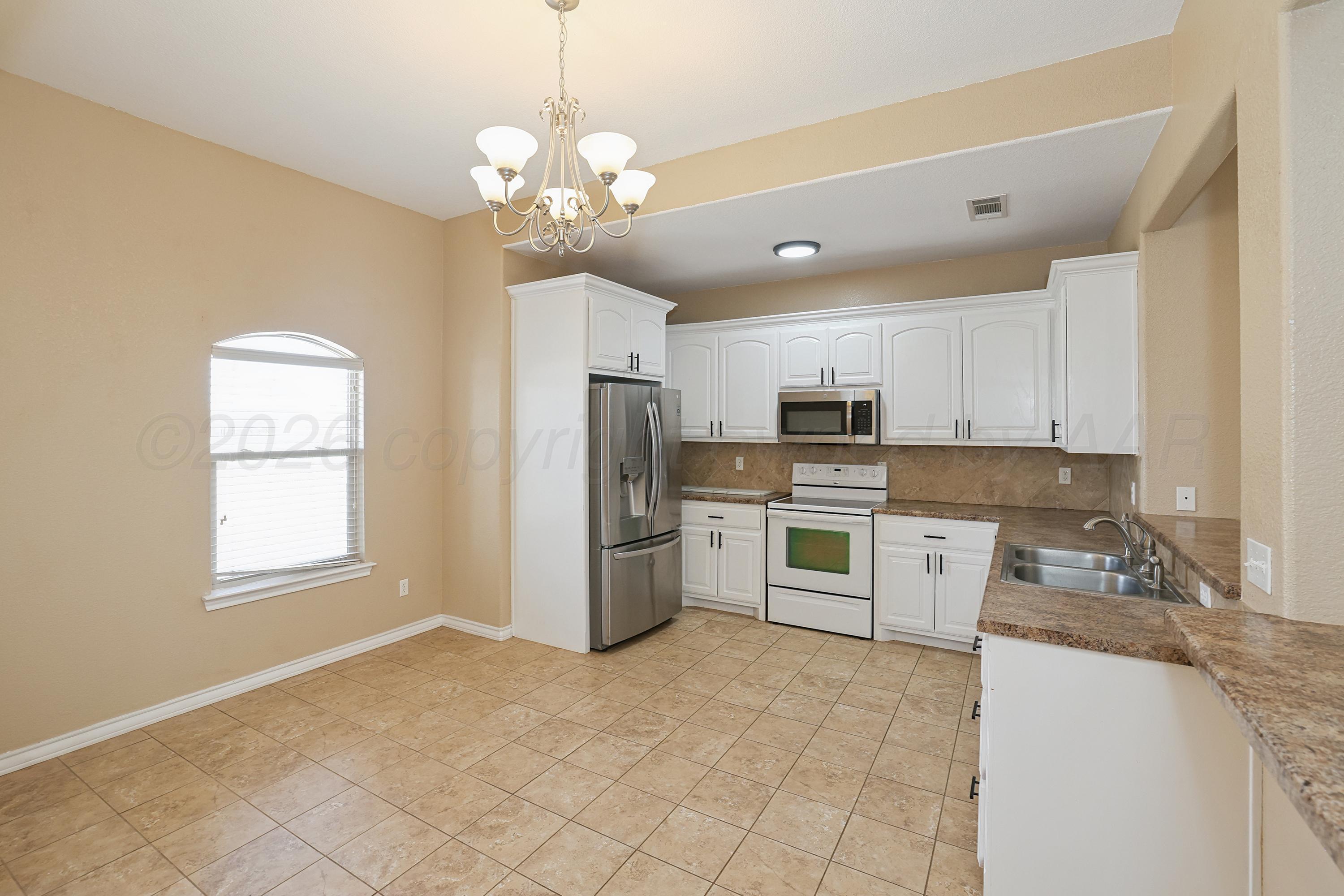 19101 Sundancer Lane Bushland, TX 79124 - Photo 4 of 25 a kitchen with stainless steel appliances granite countertop a refrigerator oven a sink dishwasher and white cabinets with wooden floor