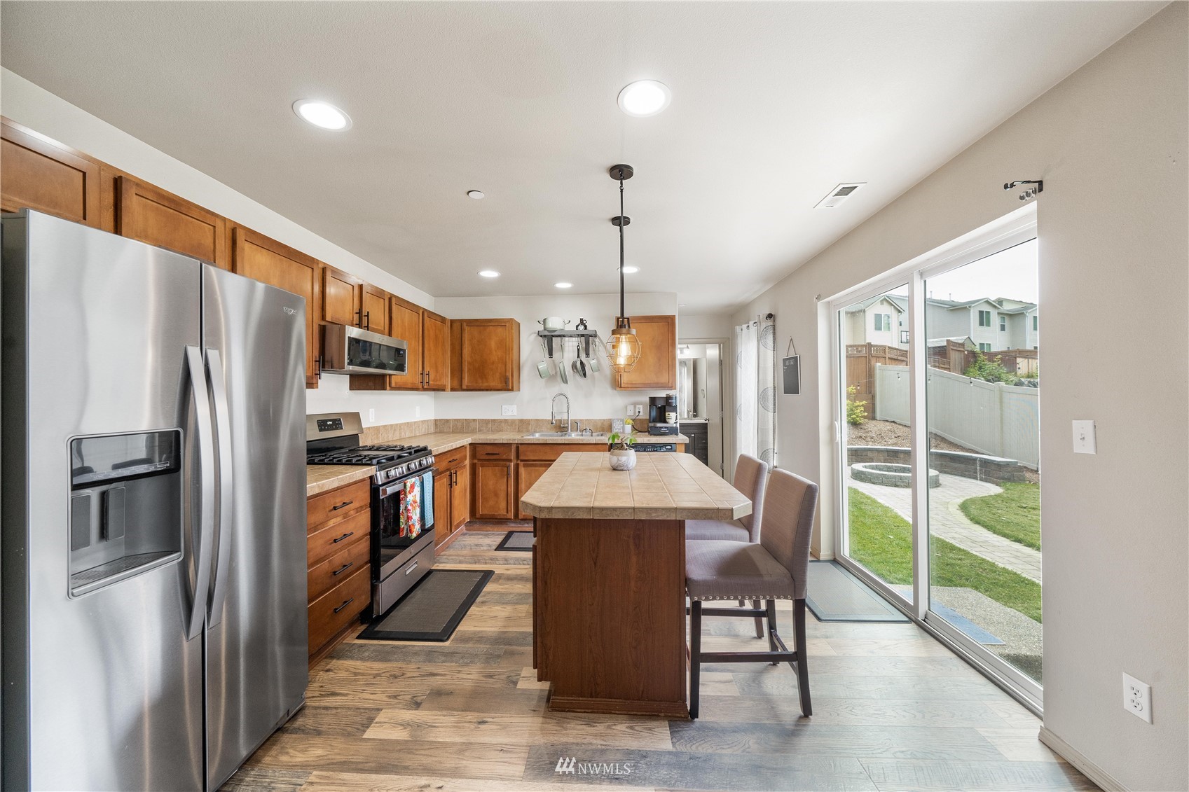 1589 Grant Avenue DuPont, WA 98327 - Photo 9 of 30 a kitchen with stainless steel appliances kitchen island granite countertop a refrigerator a sink a stove and a wooden floors