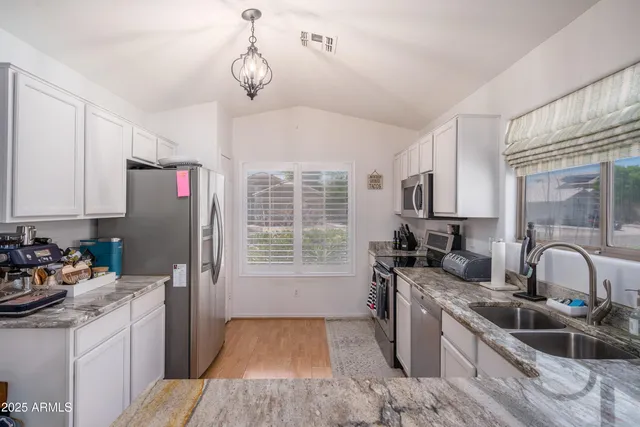 a kitchen with stainless steel appliances granite countertop a sink stove and cabinets