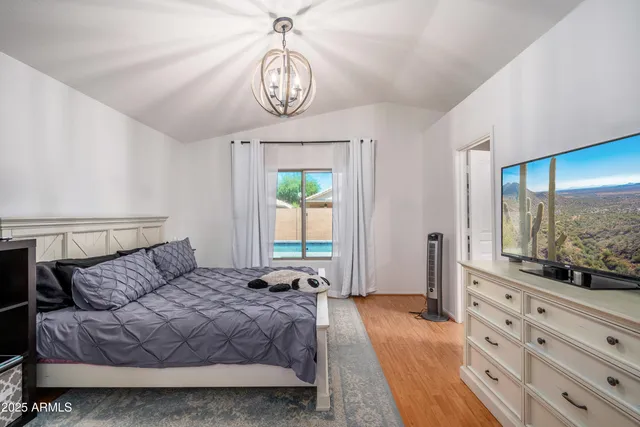 a bedroom with a bed and a flat tv screen on the dresser