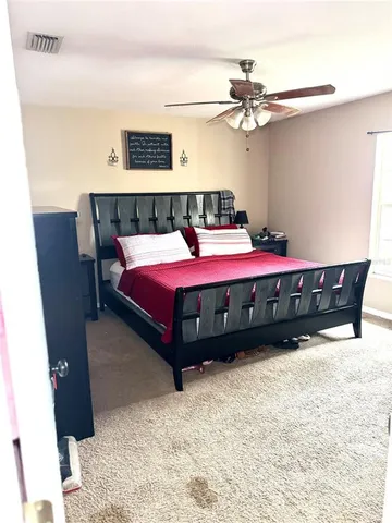 a spacious bedroom with a bed and a chandelier