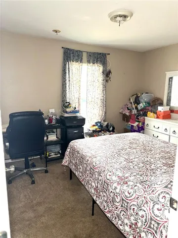 a bed sitting in a bedroom next to a window