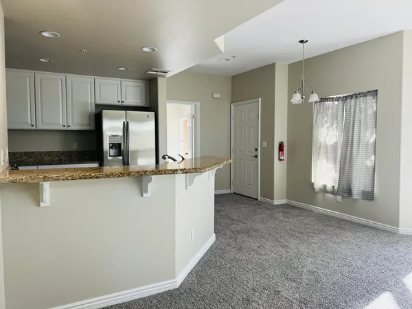a view of kitchen with stainless steel appliances granite countertop refrigerator sink and cabinets