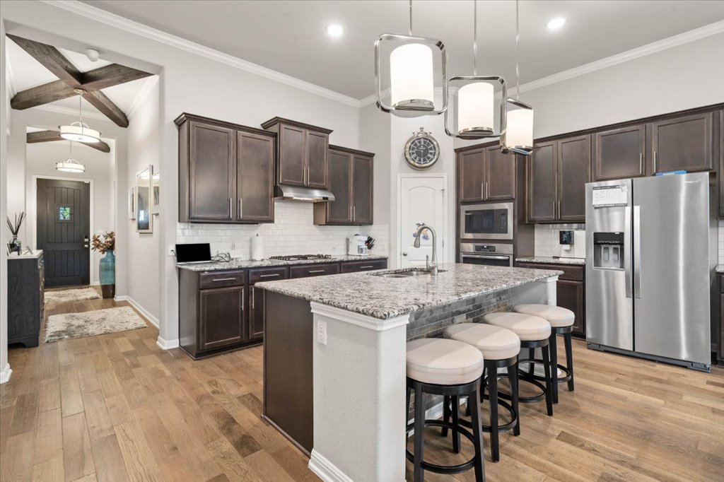 11901 Deering Place Austin, TX 78726 - Photo 7 of 40 a kitchen with stainless steel appliances a table chairs refrigerator and microwave