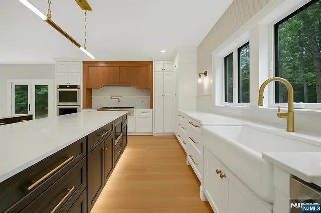 a large kitchen with kitchen island a sink a counter space and a large window