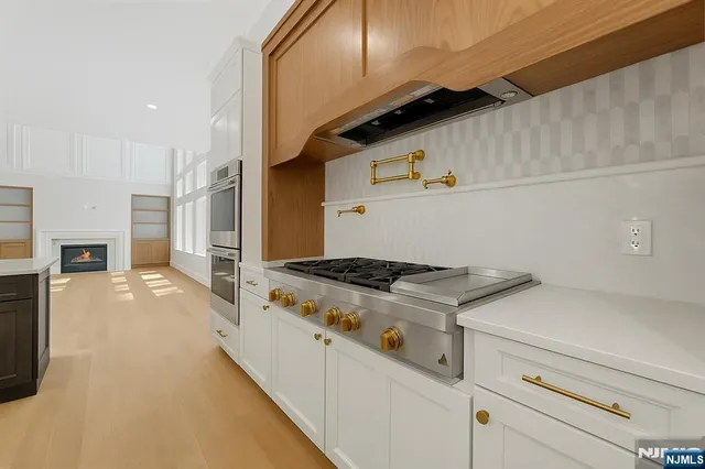 a view of a kitchen with kitchen island a sink wooden floor and a large window