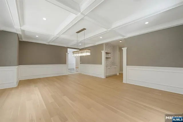 wooden floor in an empty room with a chandelier
