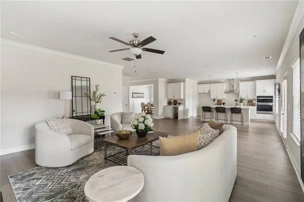 a living room with furniture and a view of kitchen