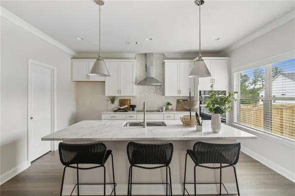 a kitchen with granite countertop a table chairs stove and cabinets