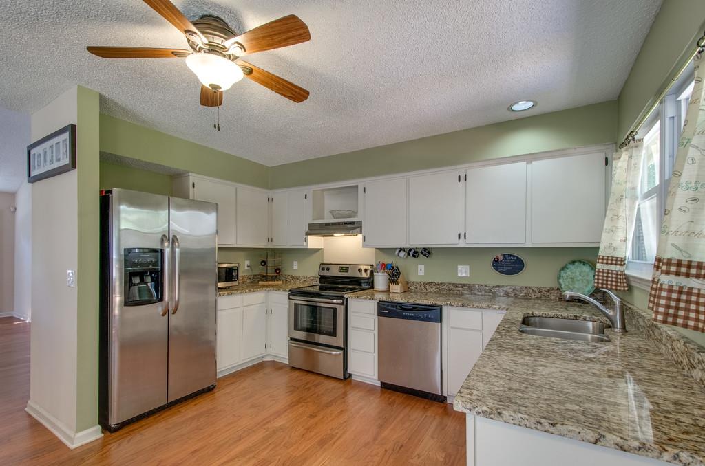 352 Cedarcliff Road Antioch, TN 37013 - Photo 8 of 22 a kitchen with stainless steel appliances granite countertop a refrigerator a stove a sink and white cabinets with wooden floor