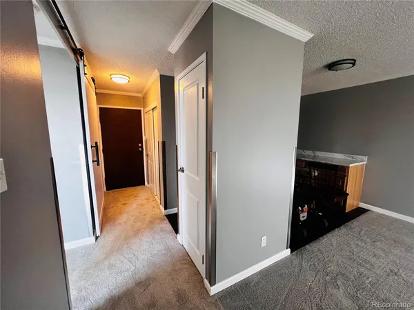 a view of a hallway with closet and wooden floor