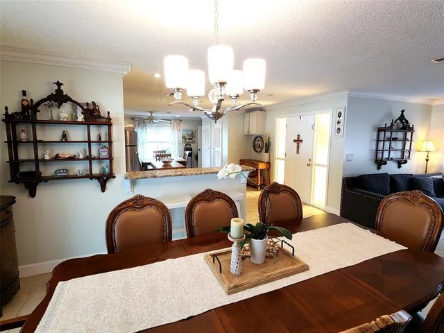 a dining room with wooden floor and chandelier