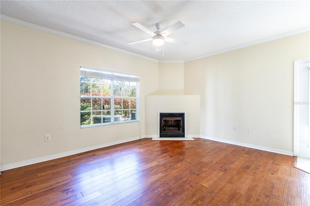 10000 Southwest 52nd Avenue, Unit 124 Gainesville, FL 32608 - Photo 26 of 33 an empty room with windows fireplace and wooden floor