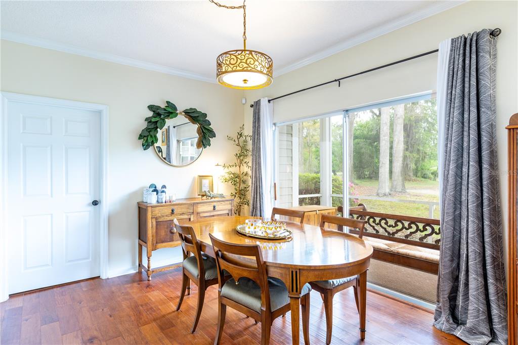 10000 Southwest 52nd Avenue, Unit 124 Gainesville, FL 32608 - Photo 4 of 33 a view of a dining room with furniture a chandelier and wooden floor