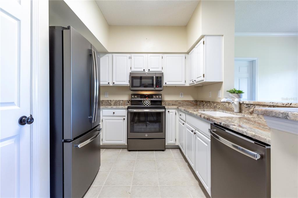10000 Southwest 52nd Avenue, Unit 124 Gainesville, FL 32608 - Photo 10 of 33 a kitchen with granite countertop a refrigerator and a sink