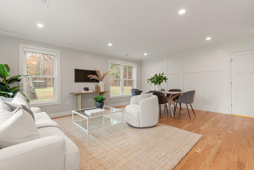 9 Barracks Road, Unit 9 Hudson, MA 01749 - Photo 7 of 16 a living room with furniture a large window and a wooden floor