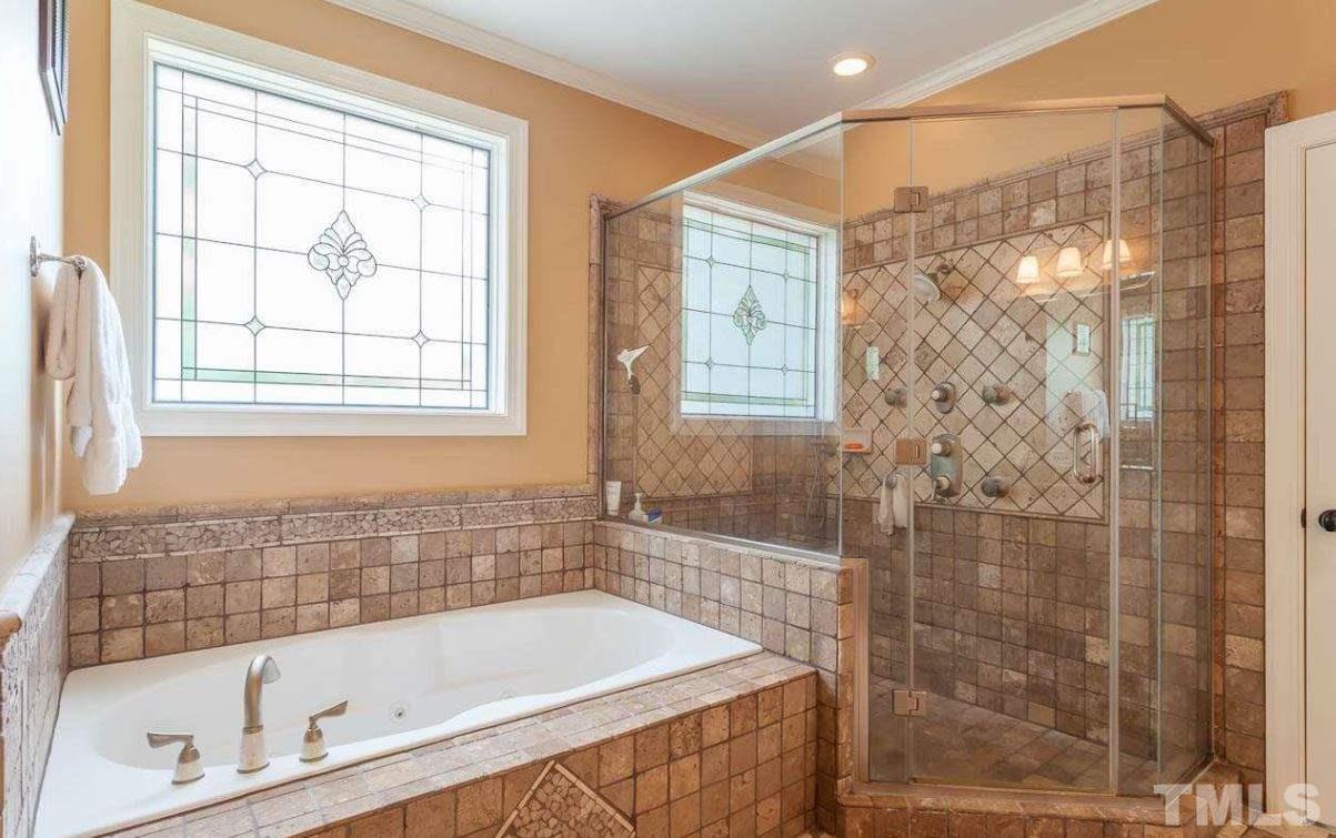 2913 Elmfield Street Raleigh, NC 27614 - Photo 18 of 30 Master Bathroom with jacuzzi tub and tiled shower with multi-mode showerhead