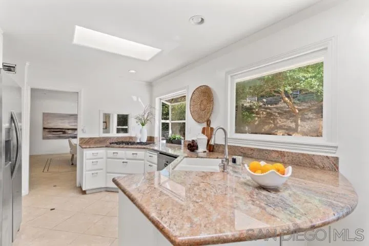 13311 Fallen Leaf Road Poway, CA 92064 - Photo 11 of 30 a view of a kitchen with kitchen island a large window cabinets and stainless steel appliances