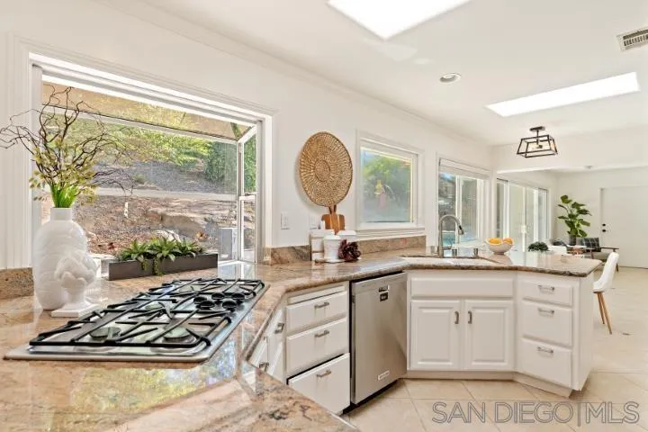 13311 Fallen Leaf Road Poway, CA 92064 - Photo 10 of 30 a kitchen with white cabinets and appliances