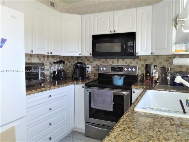 a kitchen with stainless steel appliances a stove a sink and a microwave