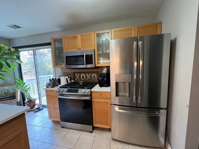 a kitchen with stainless steel appliances granite countertop a refrigerator stove a sink and a microwave