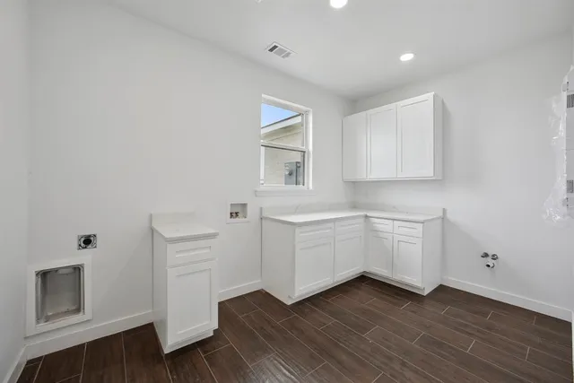 a kitchen with white cabinets and window