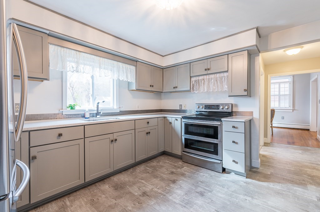 265 Main Street Sturbridge, MA 01566 - Photo 22 of 25 a kitchen with granite countertop white cabinets and white appliances