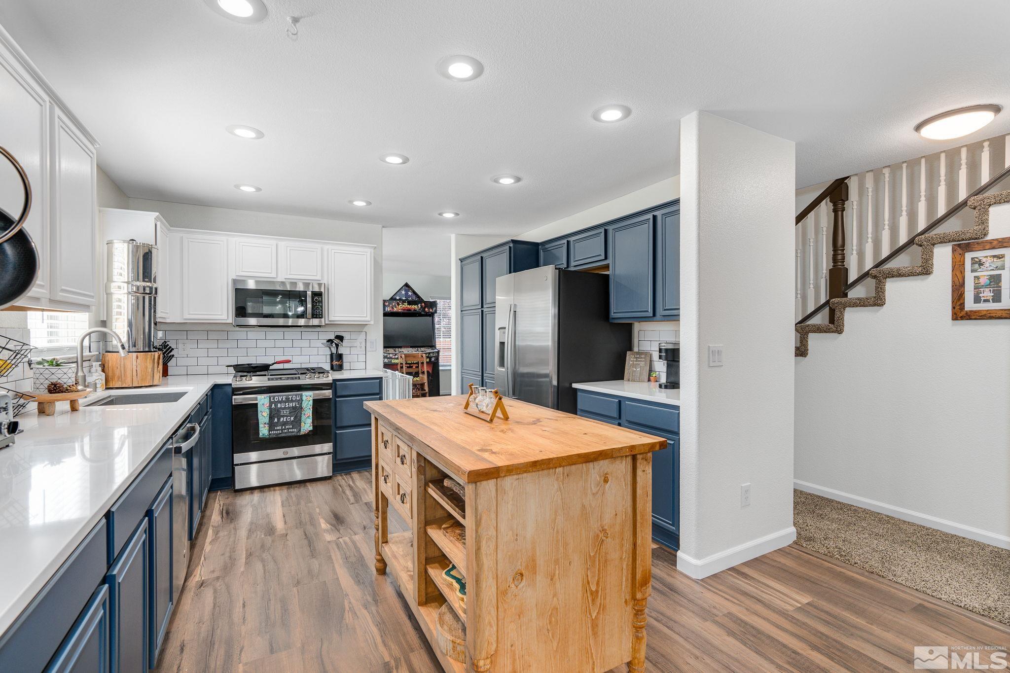 18198 Pin Oak Court Reno, NV 89508 - Photo 14 of 39 a kitchen with stainless steel appliances granite countertop a refrigerator a stove top oven and a sink with wooden floor
