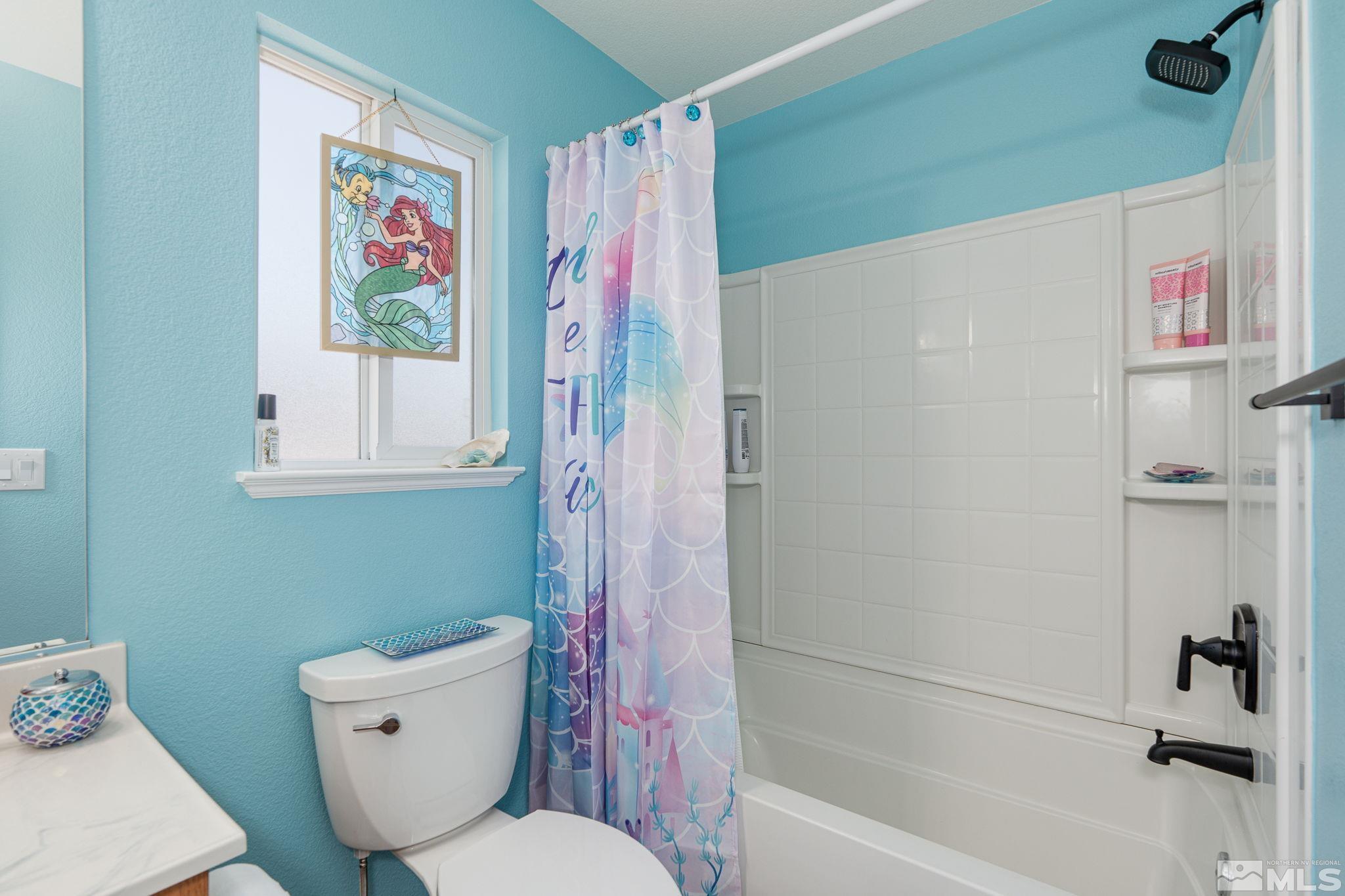18198 Pin Oak Court Reno, NV 89508 - Photo 29 of 39 a bathroom with a toilet and a shower curtain