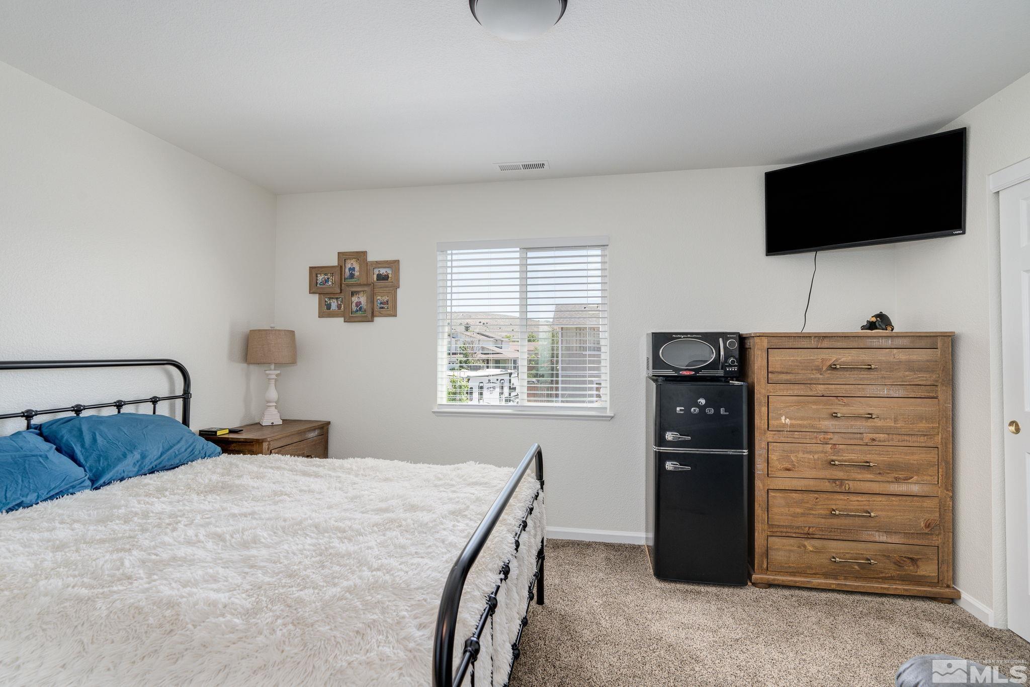 18198 Pin Oak Court Reno, NV 89508 - Photo 32 of 39 a bedroom with a bed and a flat tv screen on dresser