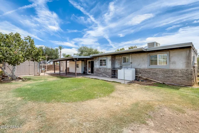 a living room with stainless steel appliances kitchen island granite countertop furniture and a large window