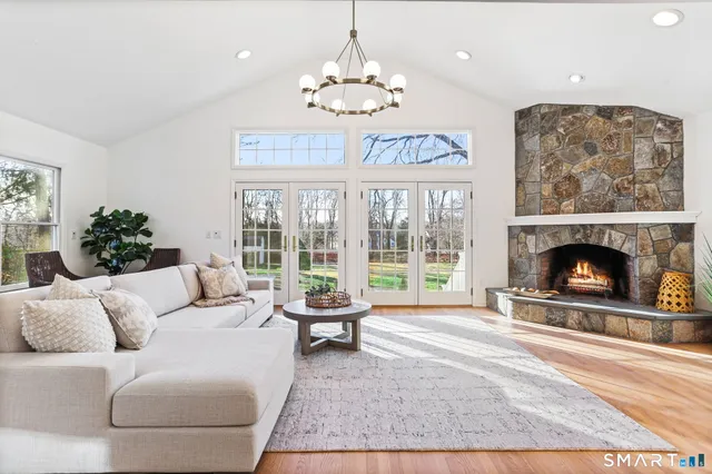 a living room with furniture a chandelier and a fireplace