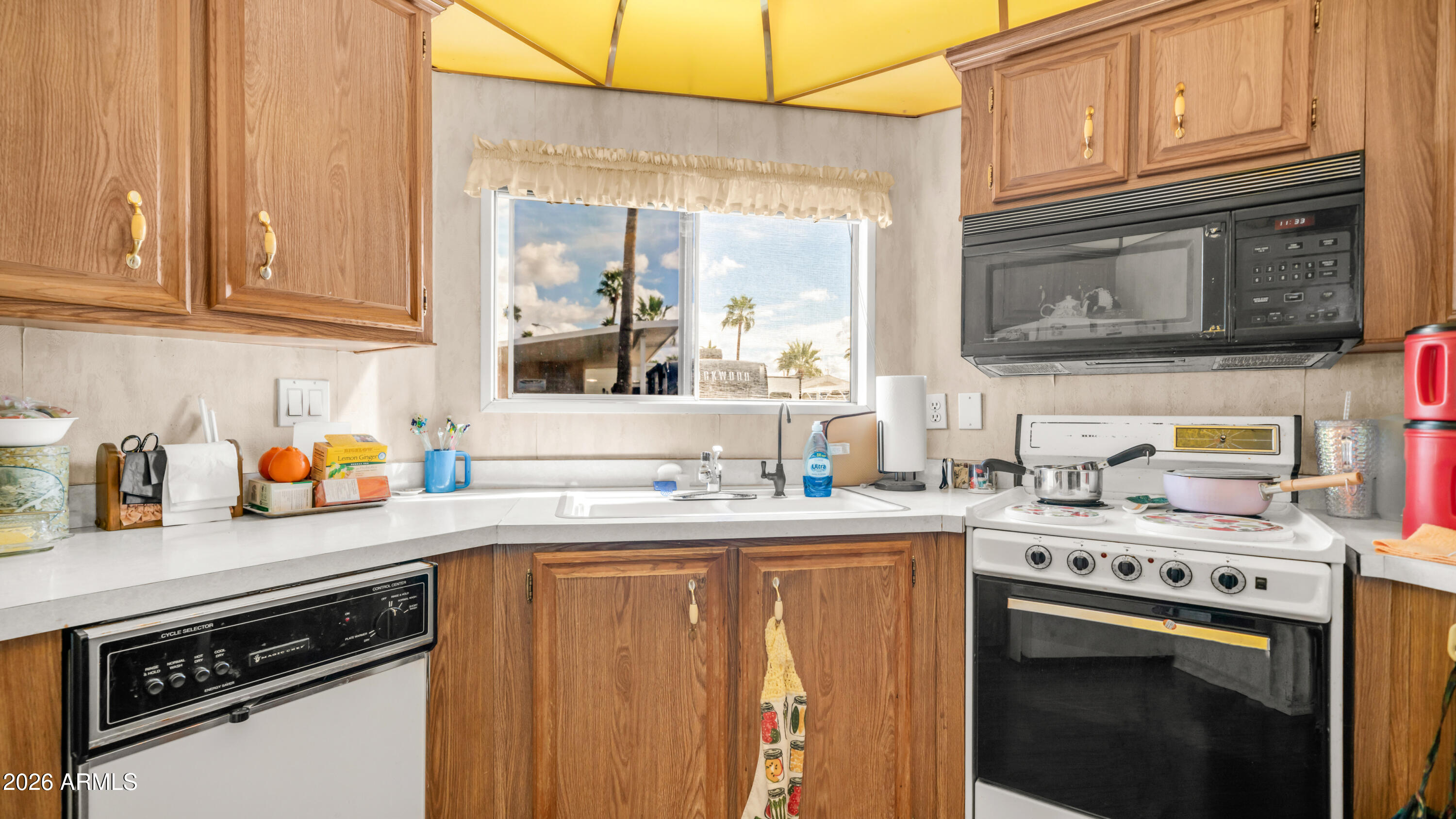 3710 South Goldfield Road, Unit 972 Apache Junction, AZ 85119 - Photo 16 of 60 a kitchen with stainless steel appliances granite countertop a sink stove and cabinets