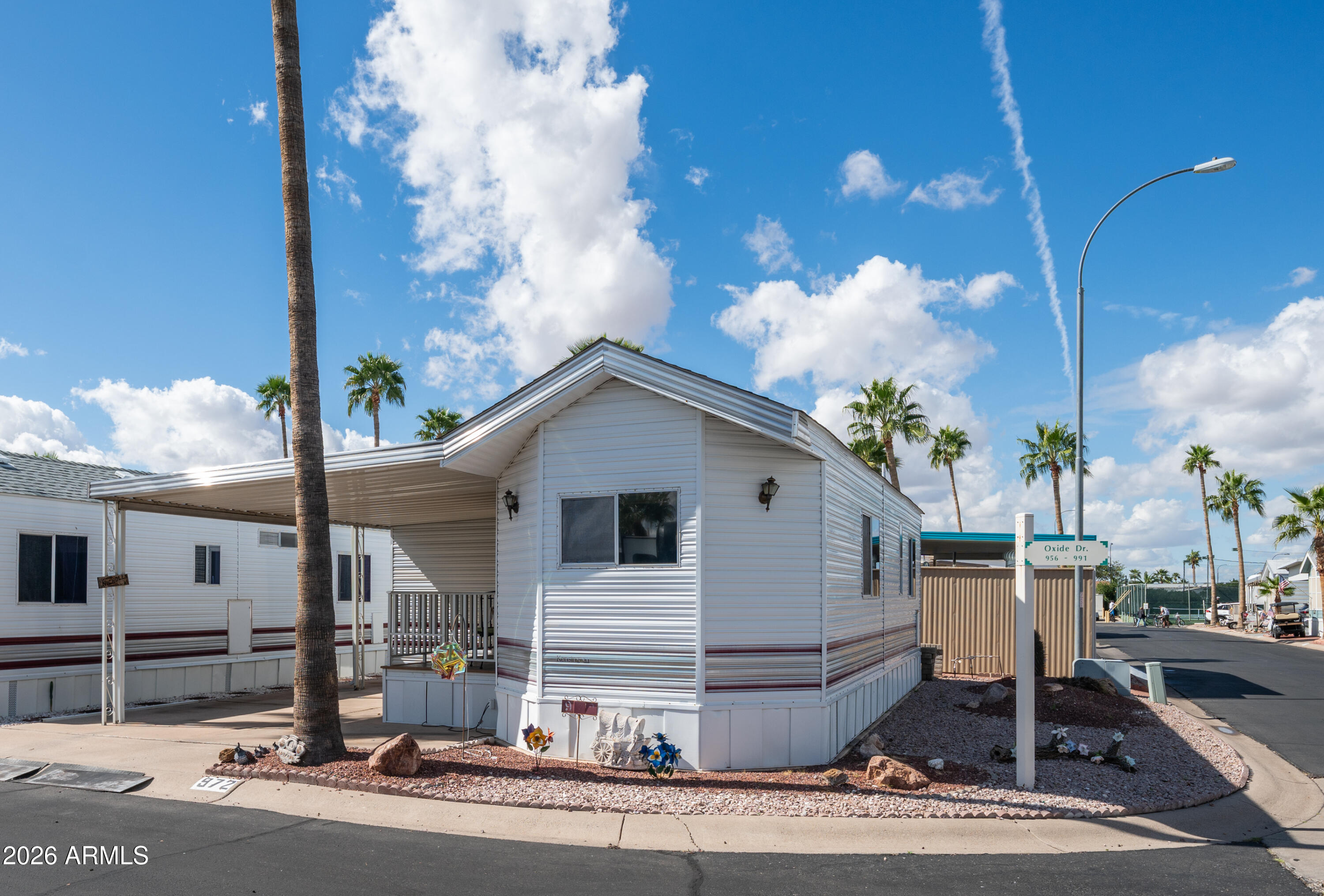 3710 South Goldfield Road, Unit 972 Apache Junction, AZ 85119 - Photo 4 of 60 a view of a white house next to a road