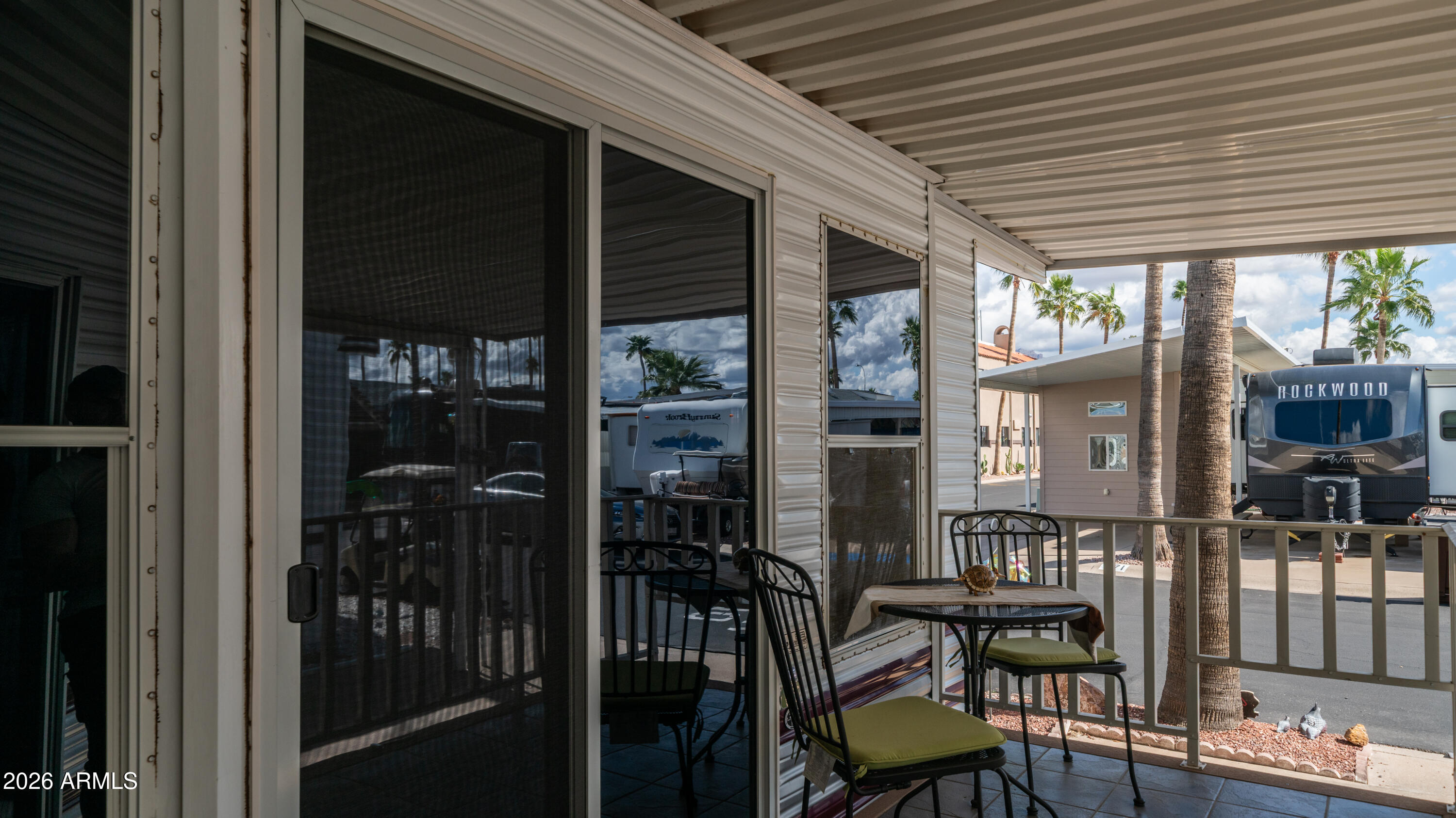 3710 South Goldfield Road, Unit 972 Apache Junction, AZ 85119 - Photo 8 of 60 a view of a patio with table and chairs and wooden floor